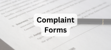 Close-up of a form with a pen resting on it, with the text "Complaint Forms" displayed. 