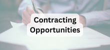 Person writing on a document at a desk, with the text "Contracting Opportunities" displayed. 