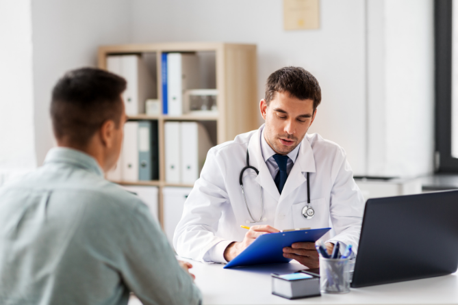 Man speaking with doctor in a healthcare setting.