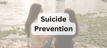 Two people sitting together by a lakeside, talking and looking out at the water, with the text "Suicide Prevention" displayed. 