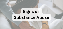 Person sitting with their head down while another person offers support, with the text "Signs of Substance Abuse" displayed.