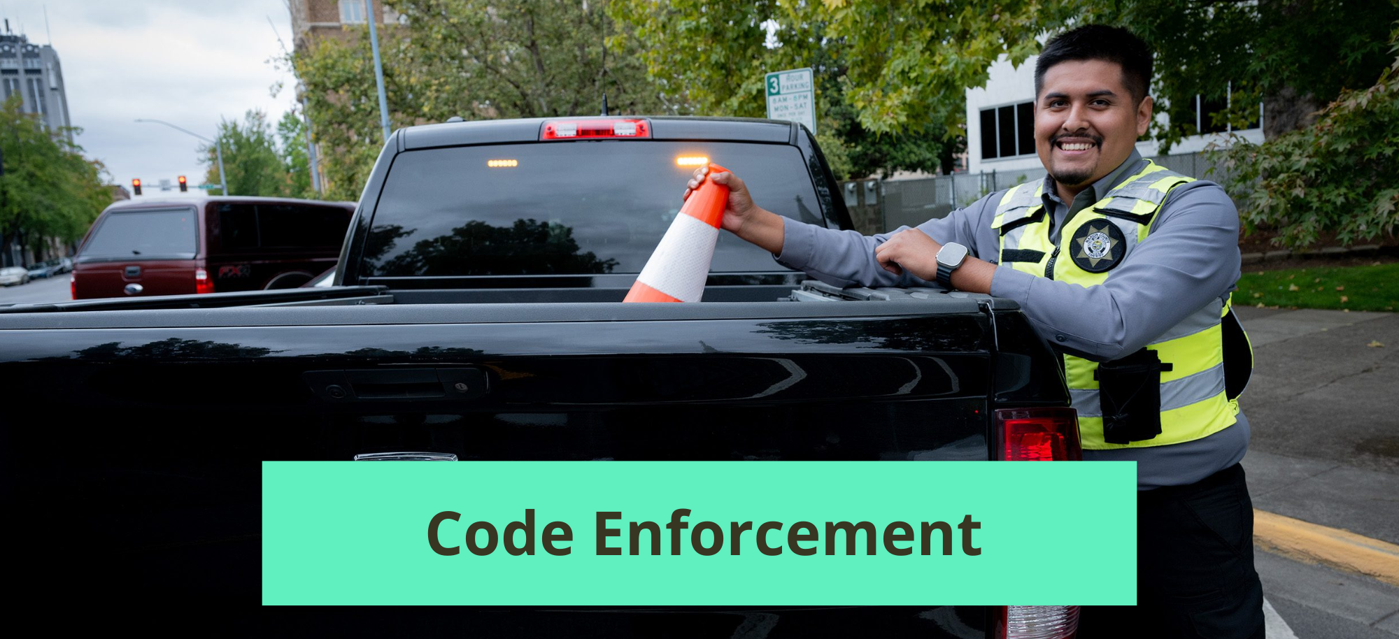 Code enforcement officer putting a cone into their work truck